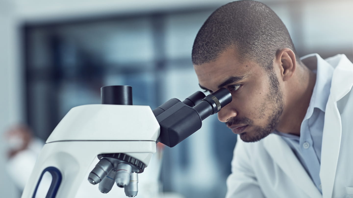 scientist in laboratory looking in microscope